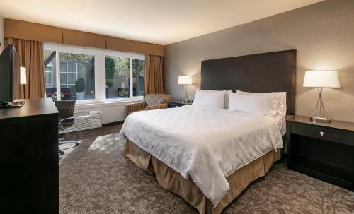 a hotel room with a large bed and a window at Pacific Stay Hotel in West Covina