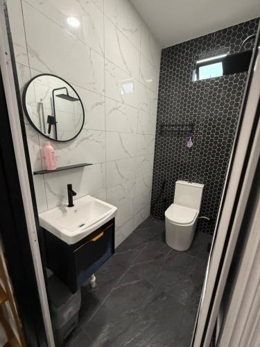 a bathroom with a sink and a toilet and a mirror at Villa Daliya Private Pool Langkawi in Langkawi Intl