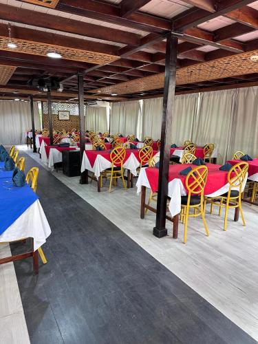 a group of tables and chairs with red and yellow tables at مركب ريفر بوت River Boat in Cairo