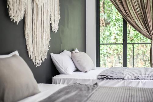 two beds in a room with a window at The Banyu House 3 in Bandung