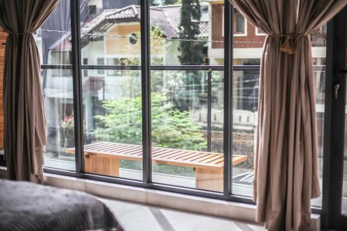 a room with a window with a wooden bench outside at The Banyu House 3 in Bandung