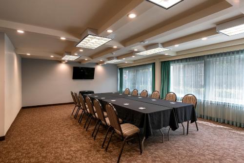 a conference room with a black table and chairs at Pacific Stay Hotel in West Covina