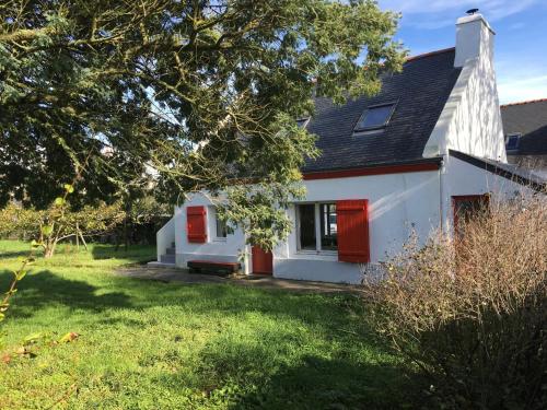 une maison blanche avec des portes rouges et une cour dans l'établissement Maison charmante au calme avec jardin à Kerlard - FR-1-813-24, à Groix