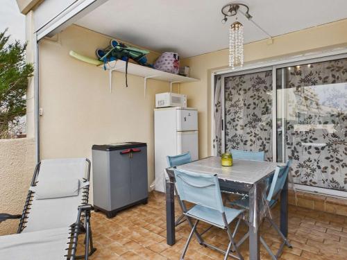 d'une salle à manger avec une table, des chaises et un réfrigérateur. dans l'établissement Studio cabine avec terrasse et parking privé à Marseillan-Plage - FR-1-326-852, à Marseillan