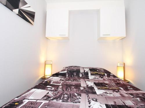 - un lit dans une chambre avec 2 fenêtres dans l'établissement T1 rénové avec goût, proche Thermes, avec WiFi - FR-1-553-302, à Balaruc-les-Bains