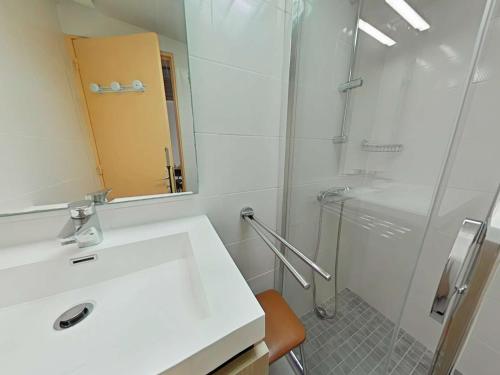une salle de bain avec un lavabo blanc et une douche dans l'établissement Maison de Vacances 2 Pièces à 100m Plage - Saint-Jean-de-Monts - FR-1-224C-343, à Saint-Jean-de-Monts