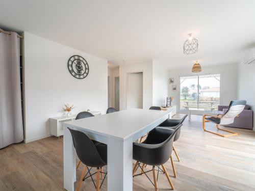 une salle à manger avec une table et des chaises blanches dans l'établissement Maison neuve pour 4 personnes proche Mimizan - Climatisation incluse - FR-1-50-169, à Saint-Paul-en-Born