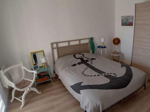 - une chambre avec un lit, une chaise et un couvre-lit dans l'établissement Charmant T2 avec Terrasse à Stella Plage, Animaux Acceptés - FR-1-236-165, à Cucq