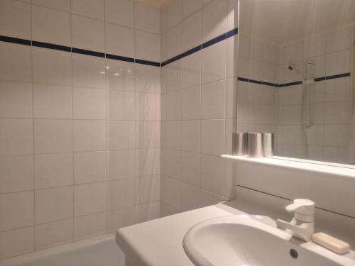 La salle de bains blanche est pourvue d'un lavabo et d'une baignoire. dans l'établissement Appartement 3 pièces - 4 pers - Vue port - FR-1-249-427, au Cap d'Agde