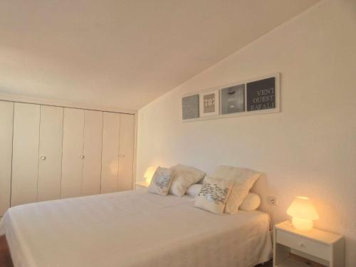 une chambre avec un lit blanc avec deux oreillers dans l'établissement Appartement 3 pièces - 4 pers - Vue port - FR-1-249-427, au Cap d'Agde