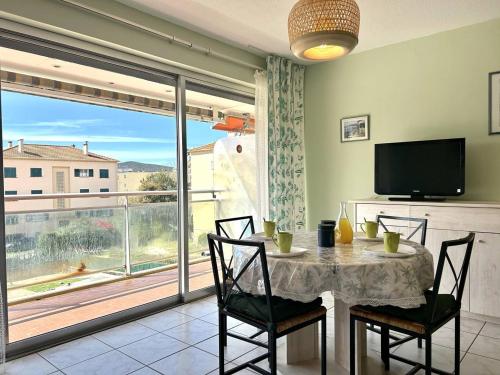 une salle à manger avec une table et des chaises et une grande fenêtre dans l'établissement Studio au Lavandou, Terrasse, Climatisation, Proche Plage - FR-1-251-857, au Lavandou