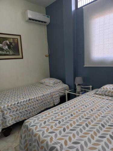 a room with two beds and a window at Del Sol Suites - Apartamento Familiar in Guayaquil