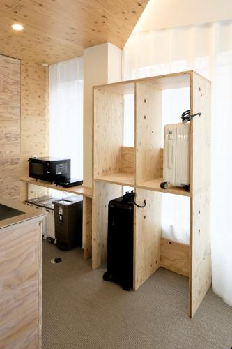 a room with a kitchen with wooden walls and a desk at SHORTsuido in Tokyo