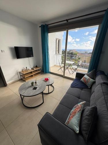 a living room with a couch and a table at Kissonerga Sea Breeze Apartments Panoramic Ocean View in Kissonerga