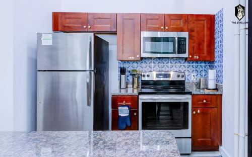 a kitchen with stainless steel appliances and wooden cabinets at The Stallion #108 - Modern Spacious Loft in Downtown with free parking in Memphis