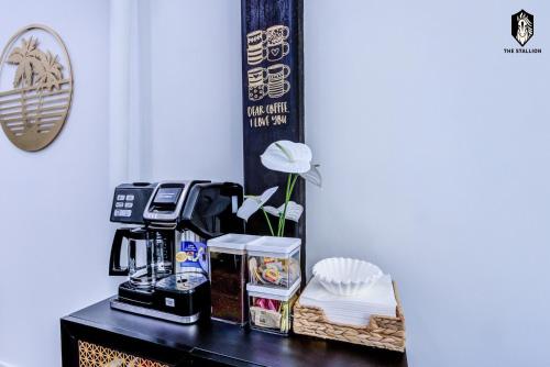 a table with a coffee maker and a flower on it at The Stallion #108 - Modern Spacious Loft in Downtown with free parking in Memphis