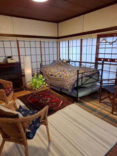 a bedroom with a bed in a room with windows at EMS Enoshima クラシックゲストハウス 寝室は個室 犬OK in Fujisawa