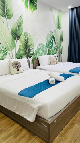 two beds in a room with plants on the wall at La La Homestay Phu Quoc in Phu Quoc