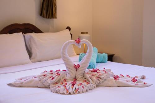two swans are forming a heart on a bed at Baan Chom View Kamala - SHA Plus in Kamala Beach