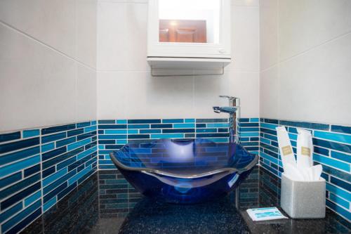 a bathroom with a blue sink and a window at Baan Chom View Kamala - SHA Plus in Kamala Beach