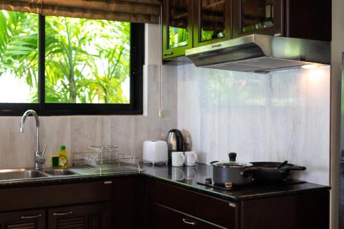 a kitchen with two pots and pans on a counter at Baan Chom View Kamala - SHA Plus in Kamala Beach