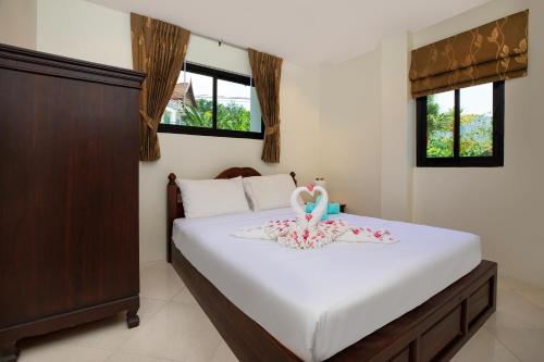 a bedroom with a bed with a swan on it at Baan Chom View Kamala - SHA Plus in Kamala Beach