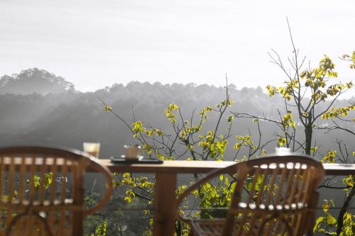 a table and chairs with a view of the mountains at KỲ VIÊN Home & Cafe in Xuân Thọ
