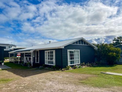 a blue house with white windows on a yard at ROBE TWO FIVE - Pet friendly outside WiFi in Robe
