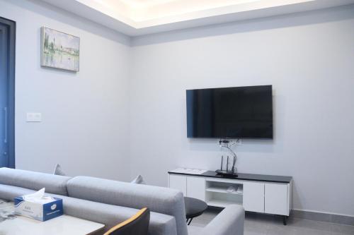 a living room with a couch and a flat screen tv at Parc21 Luxury Boutique Hotel in Phnom Penh
