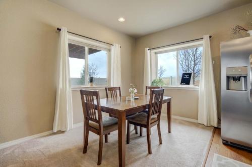 a dining room with a table and chairs and two windows at Clear Estate Spacious Retreat with BBQ & Views in Pikeview