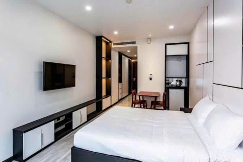 a bedroom with a large white bed and a desk at Thúy Apartment Hải Phòng in Hai Phong