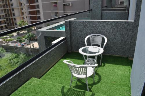 two chairs and a table on a balcony at Hotel Royal Square in Gandhinagar