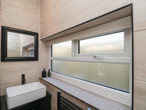 a bathroom with a sink and a window at Top Holme Cottage in York