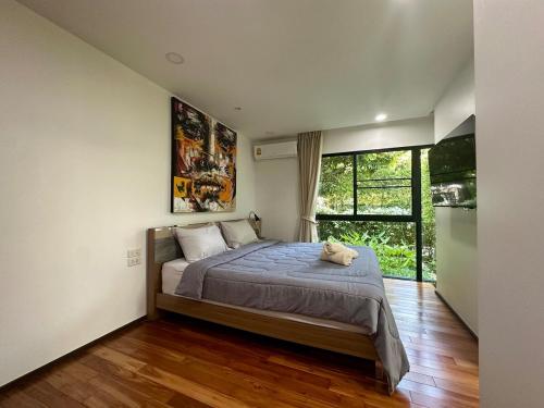 Un dormitorio con una cama grande y una ventana grande en Apartment Title III Rawai Phuket, en Rawai Beach
