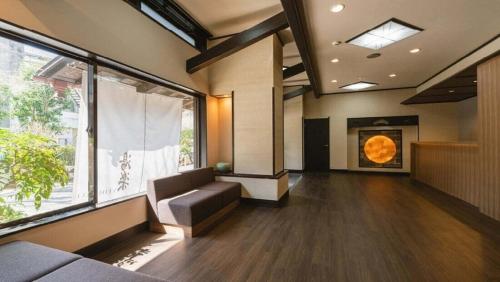 a living room with a couch and a large window at 源泉掛け流しの宿Albergo湯楽 in Yugawara