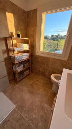 une salle de bain avec un lavabo et des toilettes et une fenêtre dans l'établissement Au pied du Garlaban, à Aubagne