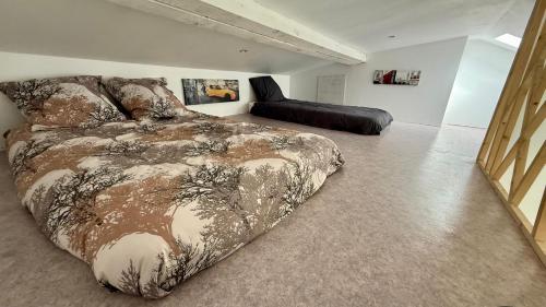 une chambre avec un lit avec une couette dessus dans l'établissement Au pied du Garlaban, à Aubagne