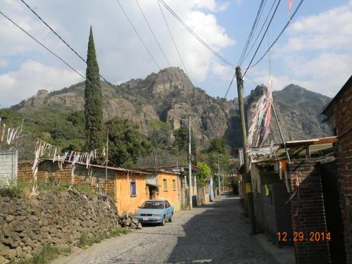 a car parked on a street with mountains in the background at Tubohotel in Tepoztlán
