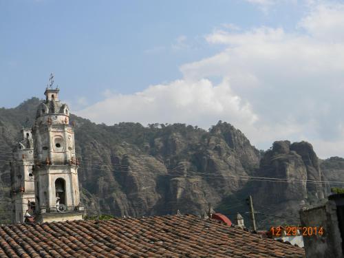 a clock tower with a mountain in the background at Tubohotel in Tepoztlán