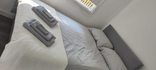 an overhead view of a white bed with two gray slippers at Sheppey days in Eastchurch