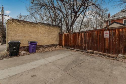 a wooden fence with two trash cans next to a driveway at Wash Park Gem Large Lower Studio Prime Location in Denver