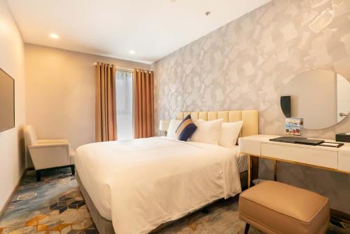 Postel nebo postele na pokoji v ubytování La Vela Saigon Hotel