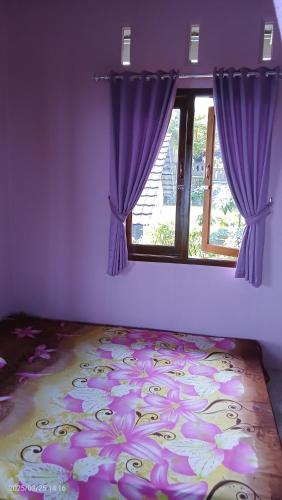 ein Schlafzimmer mit lila Wänden und einem Fenster in der Unterkunft Rumah singgah view city light in Baturaden
