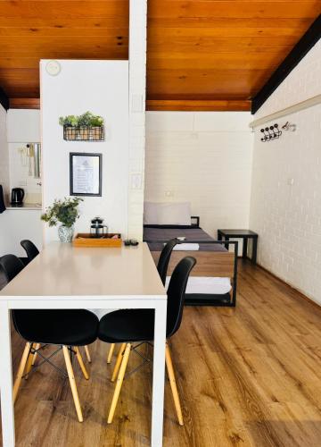 a dining room with a white table and chairs at Jetty Motel The Entrance in The Entrance