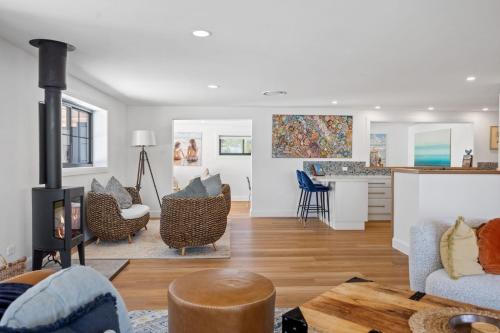 a living room with a fireplace and a kitchen at Gawura in Burrill Lake