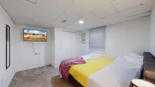 a bedroom with a bed and a tv on the wall at Cozy Mountain-Inspired Lower Unit in Denver in Denver