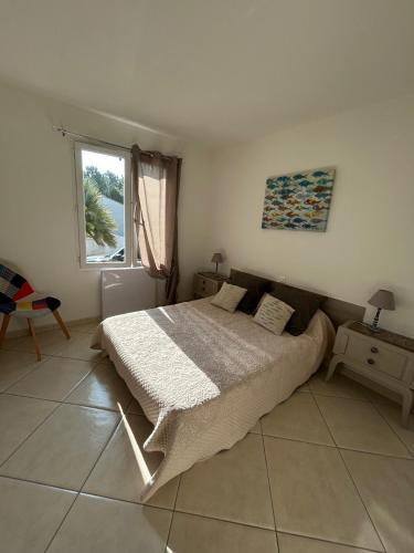 une chambre avec un grand lit et une fenêtre dans l'établissement Villa du Bonheur Carambole, à Saint-Georges-dʼOléron