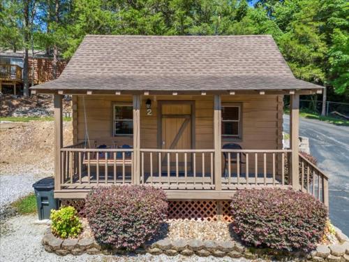 a small house with a porch and some bushes at Cozy Cabin with Breathtaking Views near Dollywood in Pigeon Forge