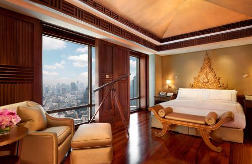 a bedroom with a bed and a large window at The Peninsula Bangkok in Bangkok