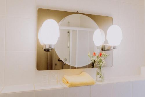 a bathroom with a mirror and a sink at LandHotel in Altlandsberg